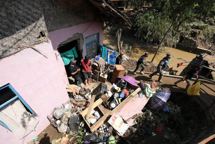 Warga beraktivitas di rumahnya yang terdampak banjir dan tanah longsor di Kampung Dayeuh Handap, Kelurahan Kota Kulon, Kecamatan Garut Kota, Garut, Jawa Barat, Selasa (19/7).