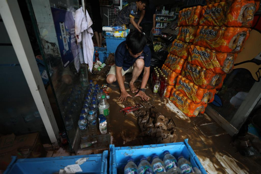 Sejumlah warga berusaha menyelamatkan beberapa jenis produk yang terdampak banjir di sebuah toko retail di Jalan Raya Bailang, Lingkungan 1, Kelurahan Bailang, Kecamatan Bunaken, Kota Manado, Sulawesi Utara, Sabtu (28/1).