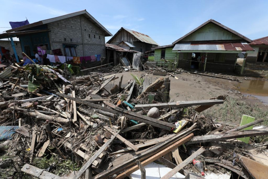Puing sampah dan potongan kayu menumpuk di depan rumah warga yang terdampak banjir bandang di Desa Torue, Kecamatan Torue, Kabupaten Parigi Moutong, Provinsi Sulawesi Tengah, Minggu (31/7).