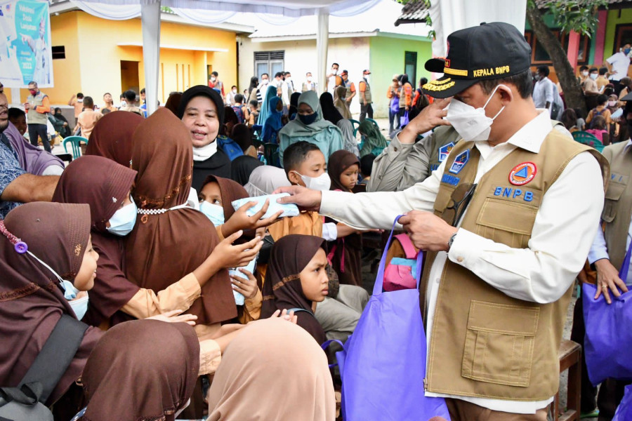 Kepala BNPB Letjen TNI Suharyanto (kanan) membagikan masker kepada siswa-siswi Sekolah Dasar Negeri (SDN) 1 Ketara, Lombok Tengah, Nusa Tenggara Barat, Rabu (16/3).