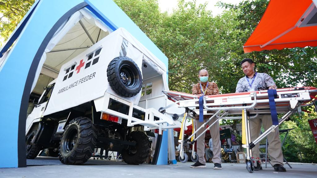 Petugas menurunkan tandu roda mobil AMMDes Ambulance Feeder yang tampil dalam Rumah Resiliensi Indonesia di Nusa Dua, Bali, Senin (23/5).