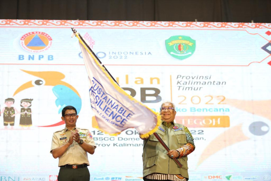 Kepala BNPB Letjen TNI Suharyanto (kiri) menyaksikan Gubernur Sulawesi Tenggara mengibarkan pataka Bulan Pengurangan Risiko Bencana (PRB) sebagai tuan rumah Bulan PRB 2023 mendatang di BSCC Dome, Balikpapan, Jumat (14/10).
