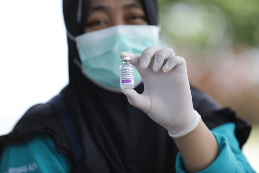 Vaksinator menunjukkan vial vaksin yang akan diberikan kepada masyarakat di kawasan Pantai Kuta Mandalika, Nusa Tenggara Barat, Minggu (13/3).