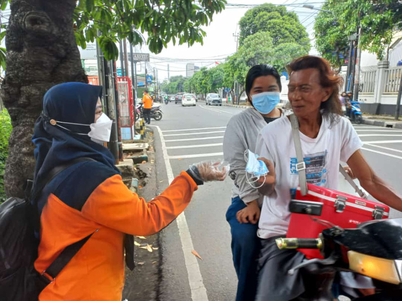 Pembagian 10.000 masker oleh Pusdiklat PB BNPB bersama BPBD Provinsi DKI Jakarta, TNI/Polri dan aparat terkait  di wilayah Kelurahan Tanjung Duren Utara, Jakarta Barat, Sabtu (12/2).