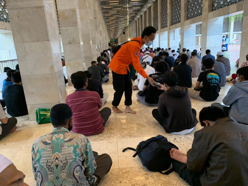 Pembagian masker gratis kepada umat muslim yang melakukan ibadah ramadan di Masjid Istiqlal, Jakarta Pusat, Kamis (7/4).