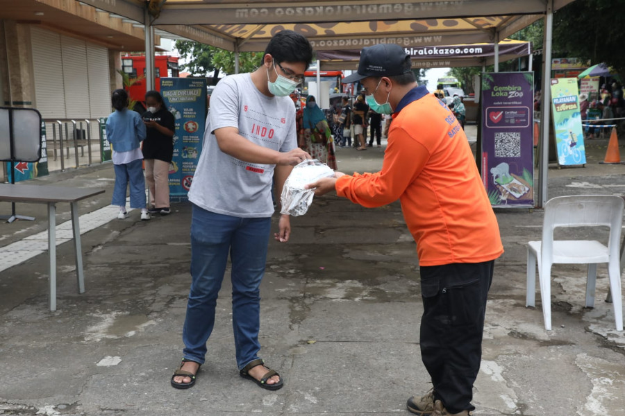 Tim Relawan membagikan masker kepada pengunjung kebun binatang Gembira Loka, Yogyakarta, Minggu (27/2).