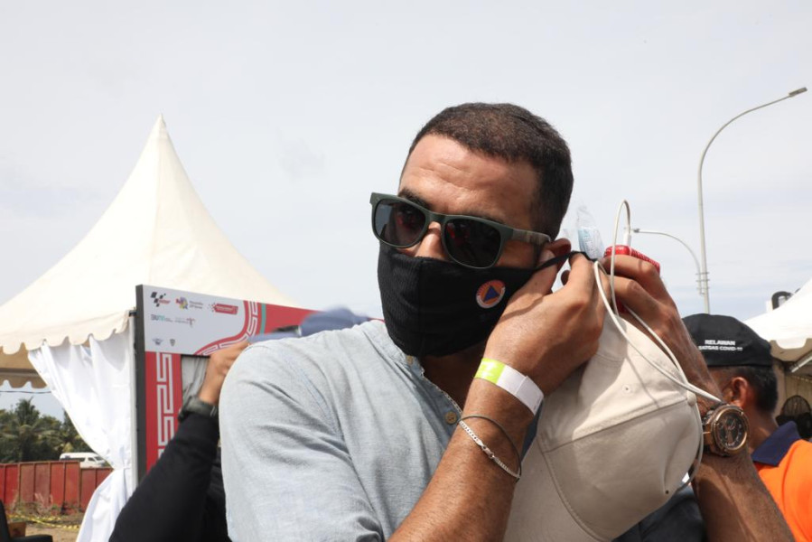 Penonton internasional menggunakan masker kain yang merupakan bagian dari paket protokol kesehatan (prokes) di Gate 3 Pertamina Mandalika International Street Circuit, Lombok Tengah, Nusa Tenggara Barat, Minggu (20/3).