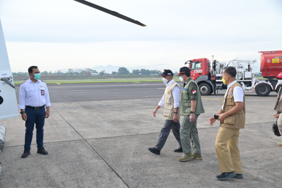 Kepala BNPB Letjen TNI Suharyanto (kemeja dan rompi hijau) bersama Menko PMK Muhadjir Effendy menuju helikopter untuk keberangkatan ke Kabupaten Cianjur dari Lanud Halim Perdana Kusuma, Jakarta, Selasa (22/11).