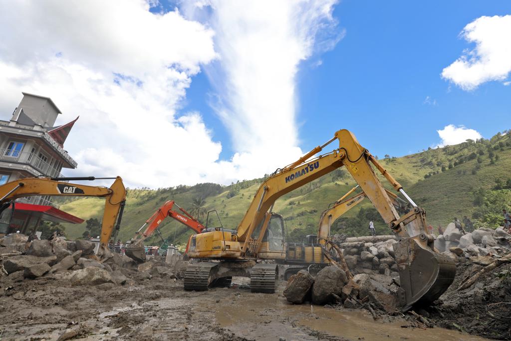 Sejumlah alat berat dikerahkan untuk menyingkirkan bebatuan yang menutup jalan sekaligus membantu proses pencarian dan pertolongan dalam peristiwa banjir bandang dan tanah longsor di Humbang Hasundutan, Sumatera Utara, Senin (4/12).