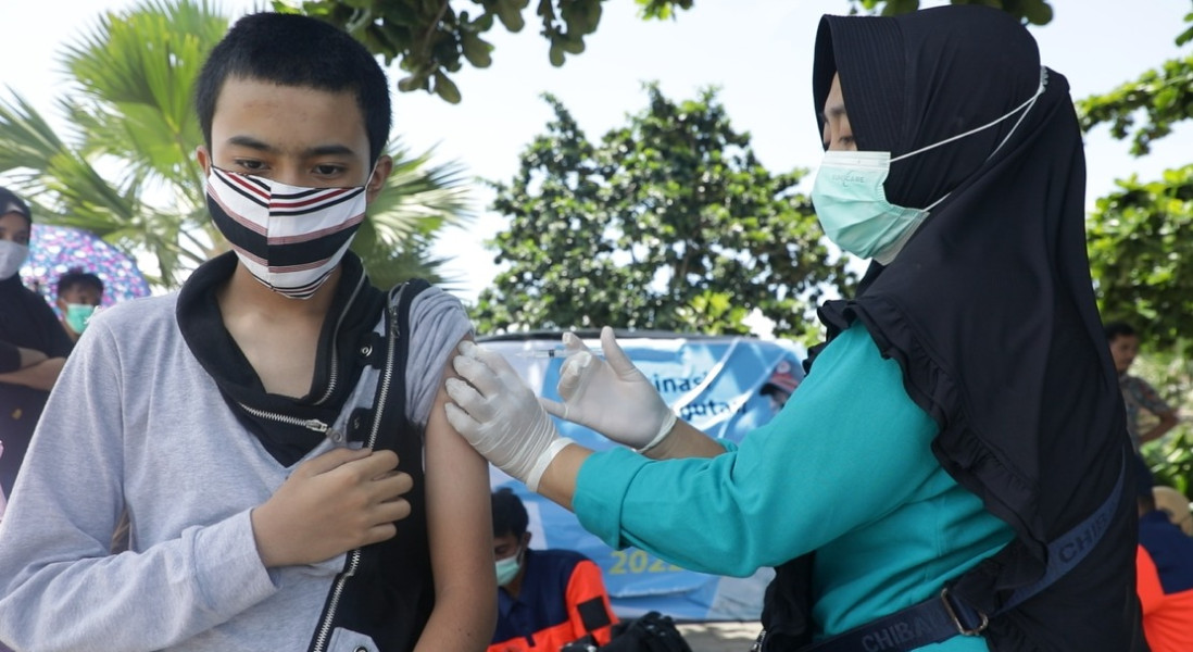 Salah satu wisatawan melakukan vaksinasi di gerai vaksinasi yang berada di kawasan Pantai Kuta Mandalika, Nusa Tenggara Barat, Minggu (13/3).