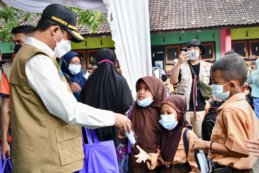 Kepala BNPB Letjen TNI Suharyanto (kiri) membagikan masker kepada siswa-siswi Sekolah Dasar Negeri (SDN) 1 Ketara, Lombok Tengah, Nusa Tenggara Barat, Rabu (16/3).