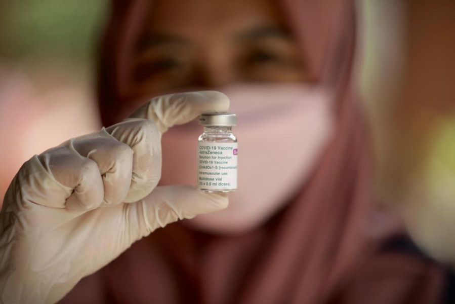 Vaksinator menunjukkan vial vaksin yang akan diberikan dalam program vaksinasi lanjutan yang diinisiasi BNPB dan Pemerintah NTB di Desa Adat Sade, Rembitan, Pujut, Lombok Tengah, NTB, Senin (1
