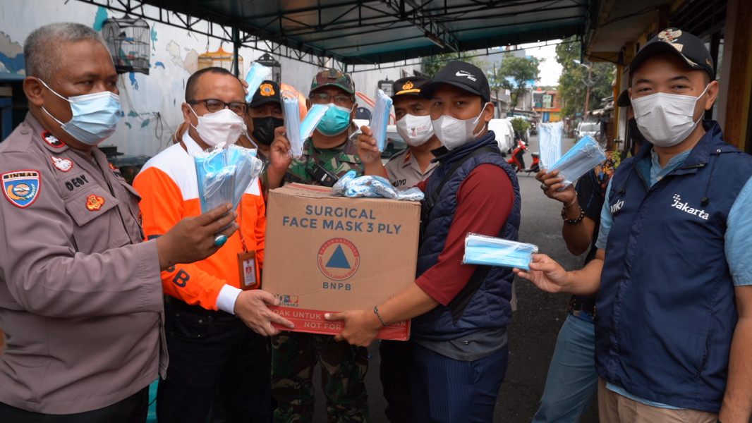 Penyerahan bantuan masker BNPB kepada masyarakat di Kelurahan Krukut, Jakarta Barat, Jumat (11/2).
