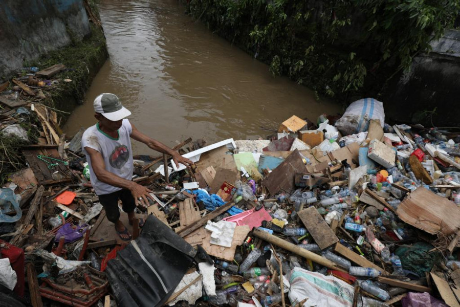 Warga memungut sampah yang tersumbat di bawah jembatan Sungai Bailang di Jalan Raya Bailang, Lingkungan 1, Kelurahan Bailang, Kecamatan Bunaken, Kota Manado, Sulawesi Utara, Sabtu (28/1).