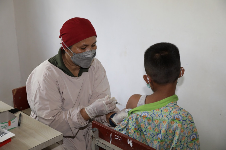 Vaksinator menyuntikkan vaksin Covid-19 kepada seorang siswa di SD 009 Sei Beduk, Kota Batam, Kepulauan Riau, Kamis (24/3).