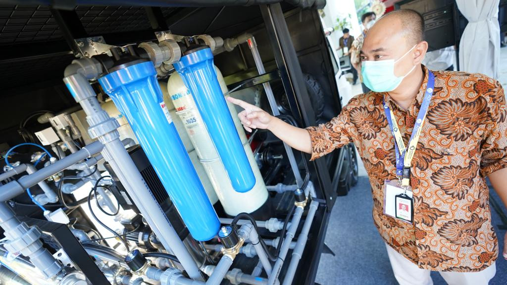 Petugas menunjukkan filter pengolah air bersih di mobil AMMDes Penjernih Air yang tampil dalam Rumah Resiliensi Indonesia di Nusa Dua, Bali, Senin (23/5).